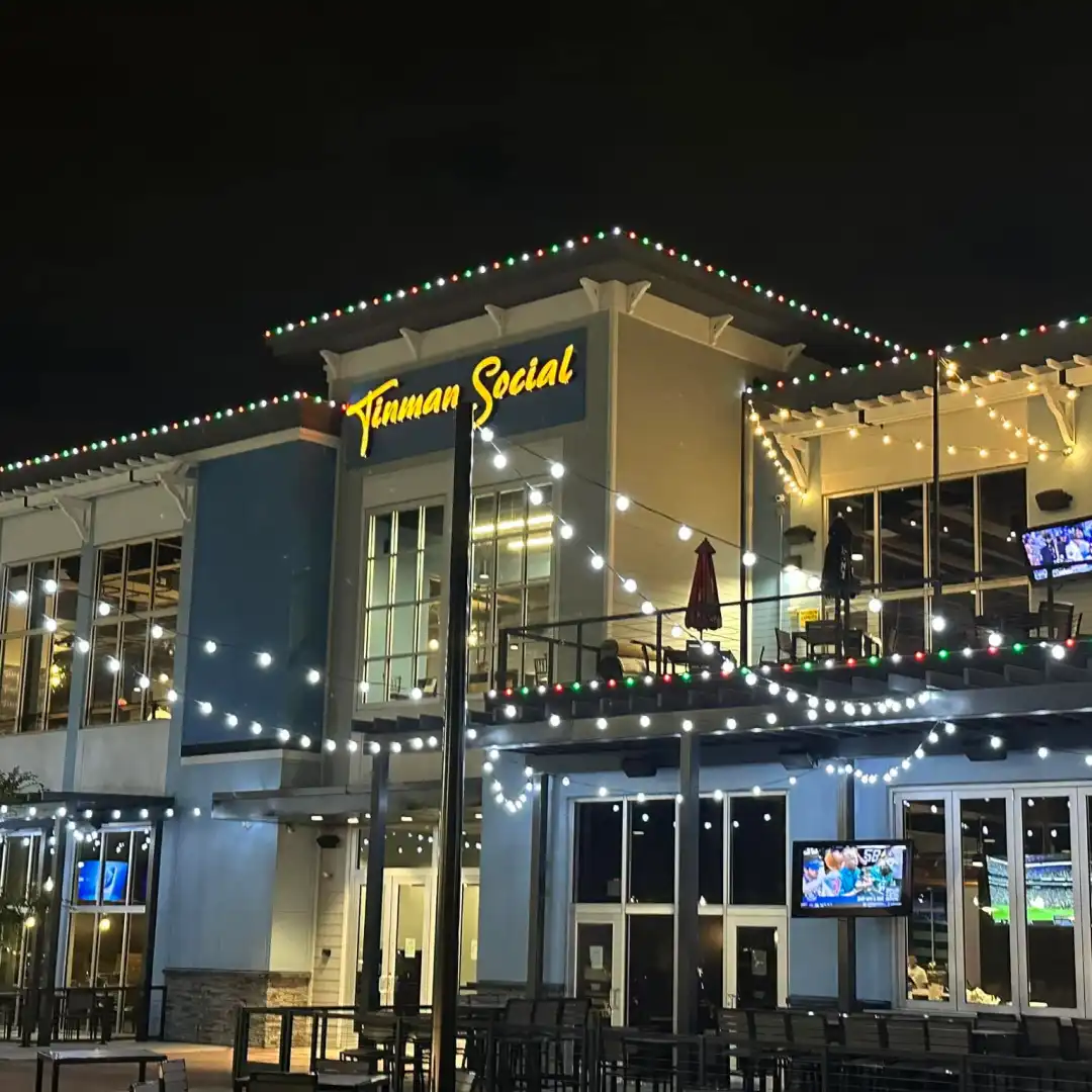 Permanent Christmas lights on the roofline and landscape of a home, synced in one color scene