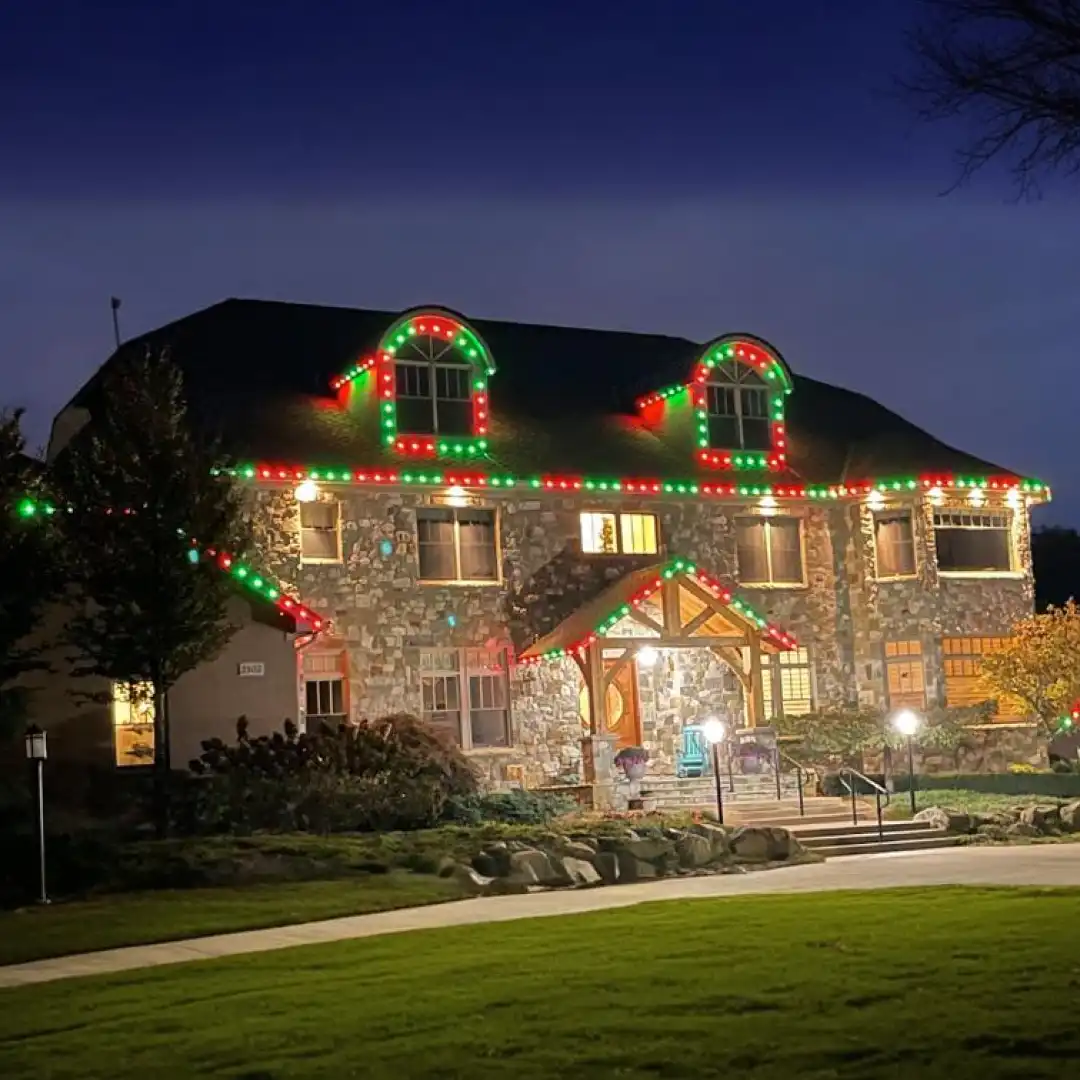 Peppermint red and white permanent outdoor Christmas lights on a two-story home with gables